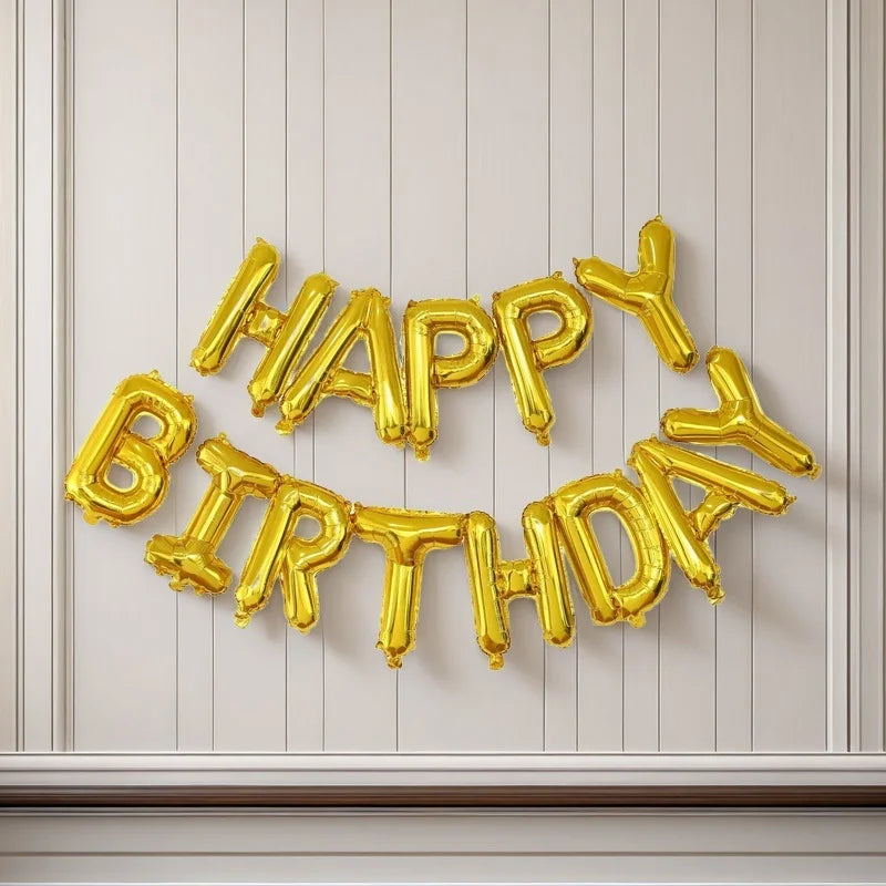 A gold foil balloon set spelling out Happy Birthday in individual letter balloons against a light background.