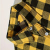 A close-up of a men's yellow and black plaid flannel shirt with button details.