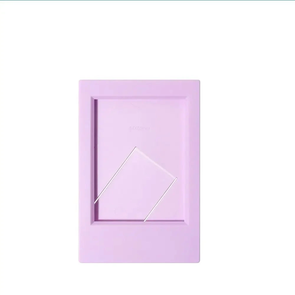 A rectangular pink mini film frame for Fuji Instax instant photos with a silver diagonal cutout.