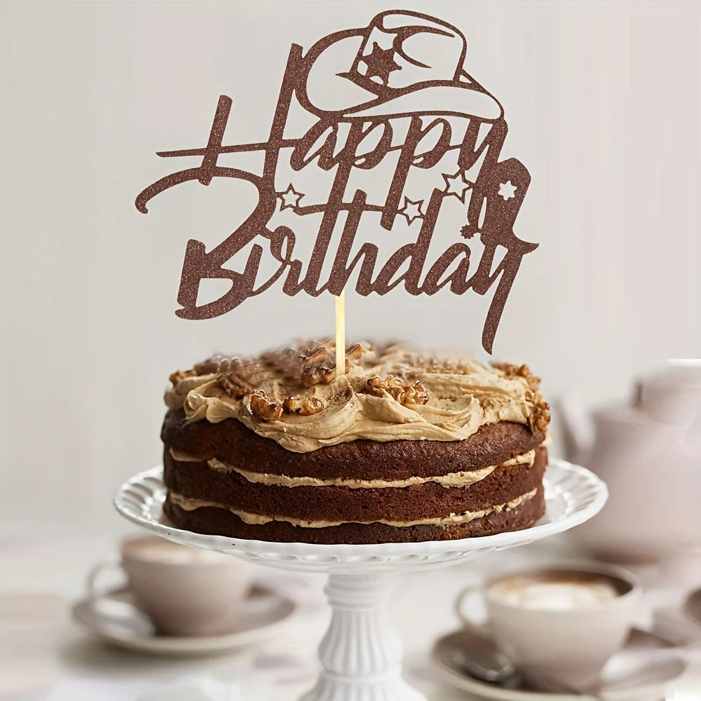 A dark chocolate birthday cake with a rustic brown topper shaped like a cowboy hat and text.