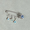 An elegant gold and silver evil eye brooch pin featuring multiple blue and white glass eyes.