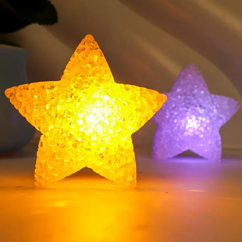 A bright yellow LED star light next to a purple star light on a surface.