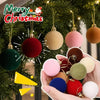 A hand holds five velvet flocked Christmas tree ornaments in various colors including green, red, pink, gold, and blue.