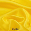 Yellow satin fabric draped and folded for sewing or DIY projects