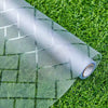Roll of frosted electrostatic window film with a geometric pattern laid on green grass