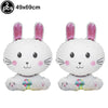 Two white cartoon bunny foil balloons with pink ears and colorful feet