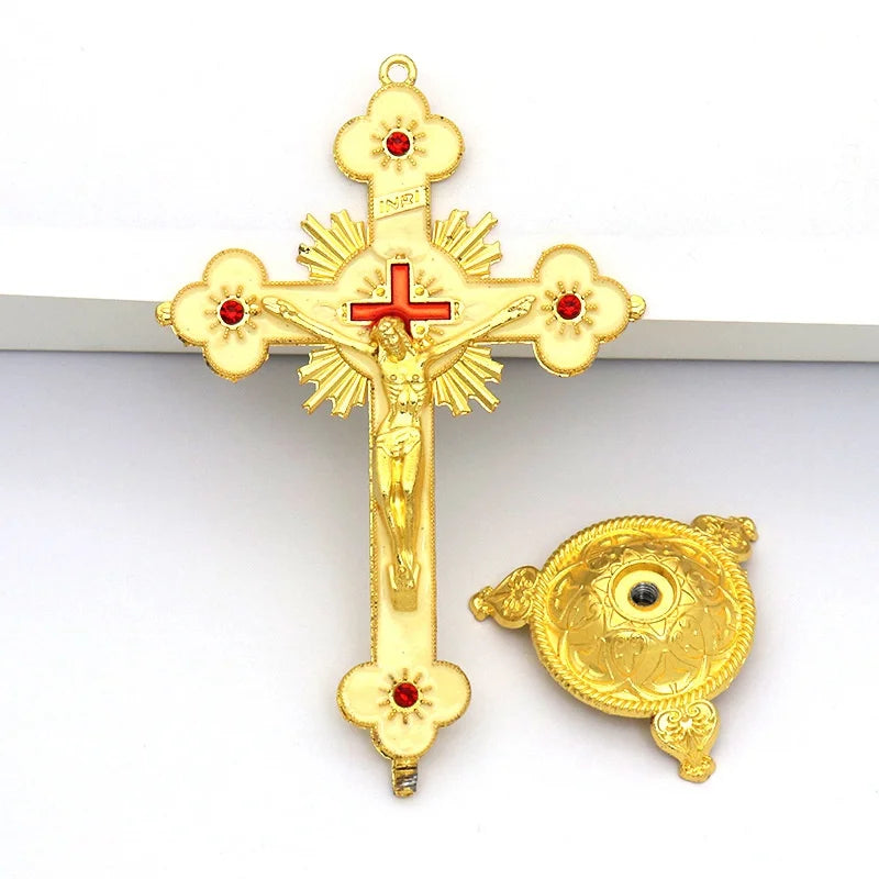 Gold crucifix figurine with a cross and a decorative stand on a white background.