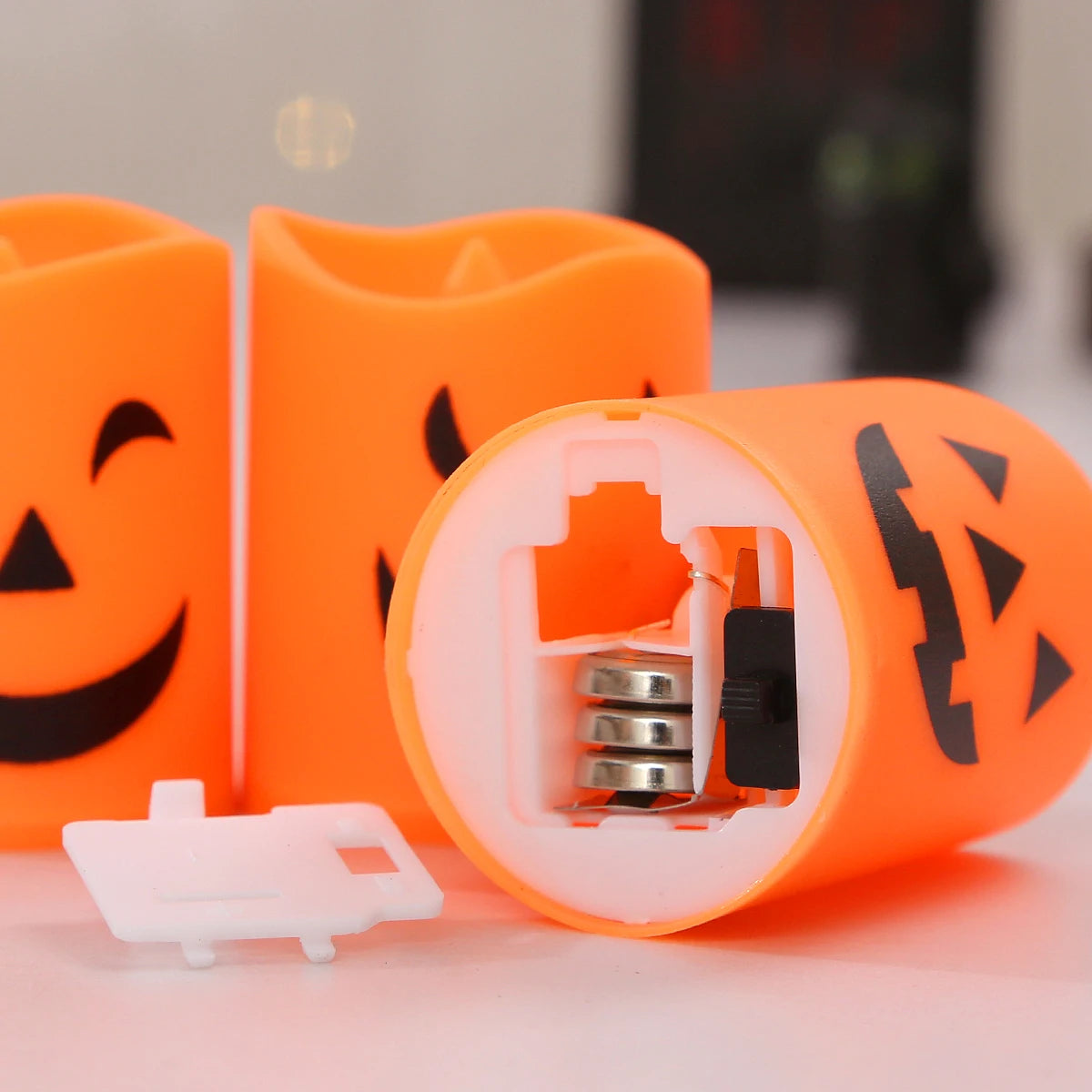 A set of six orange battery-powered LED Halloween candles with flickering flames displayed on a white surface.