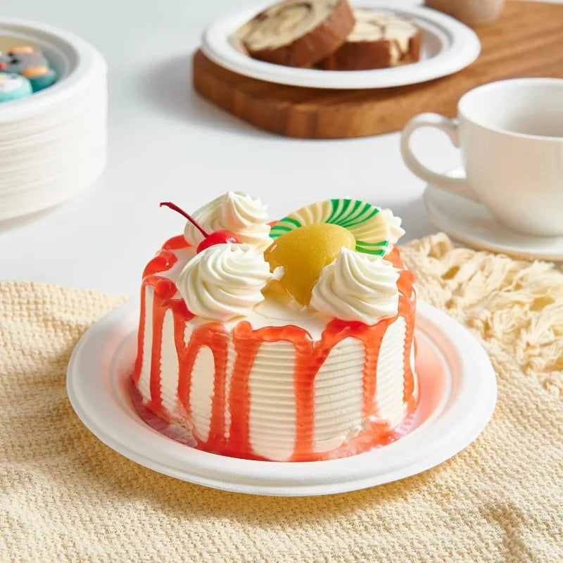 A colorful layer cake with white frosting, orange glaze, and yellow fruit garnishes sits on a white plate.