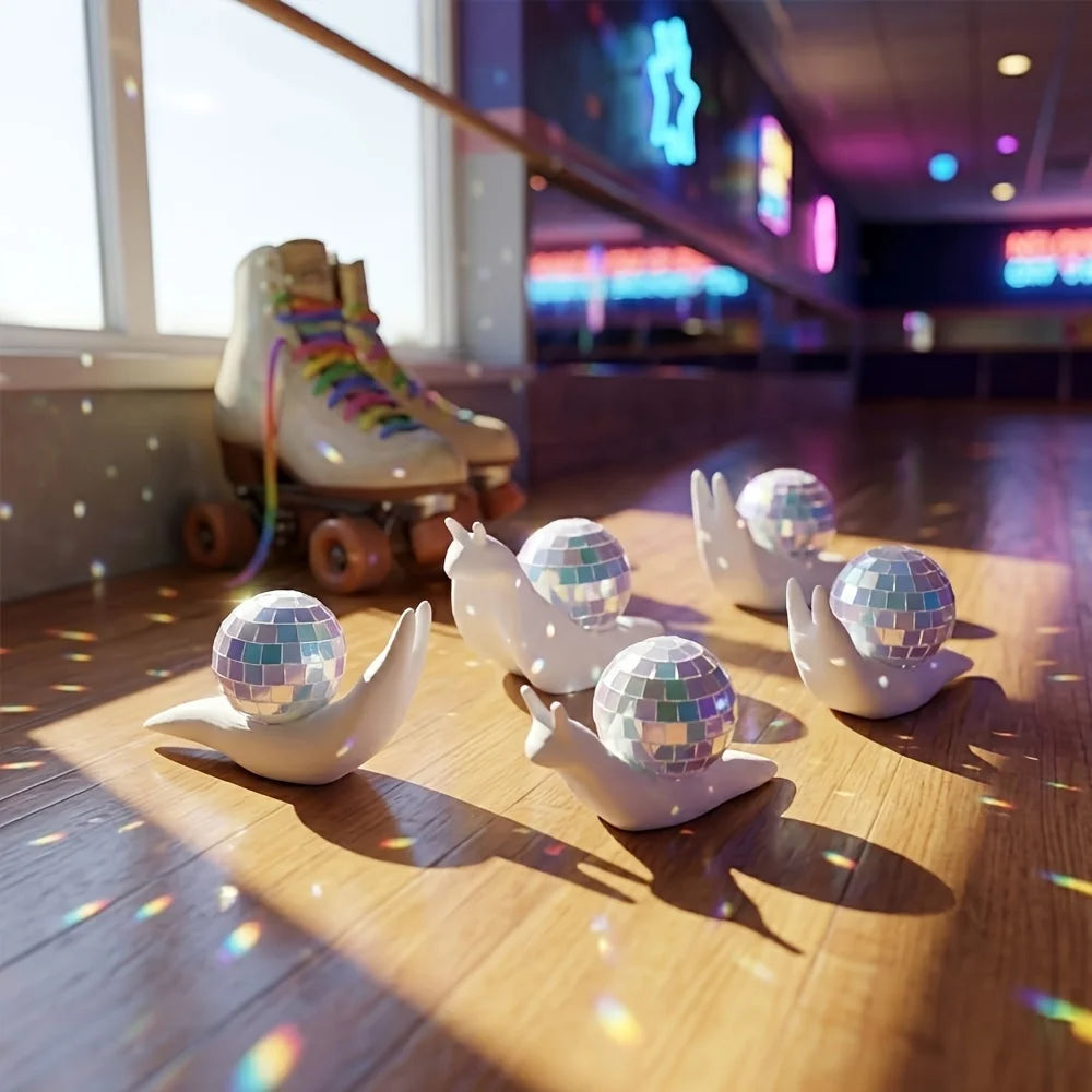 White snail shaped disco balls scattered on a wooden floor with sunlight streaming through a window.