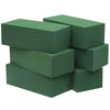 A stack of rectangular, dark green floral foam blocks used for party decoration.