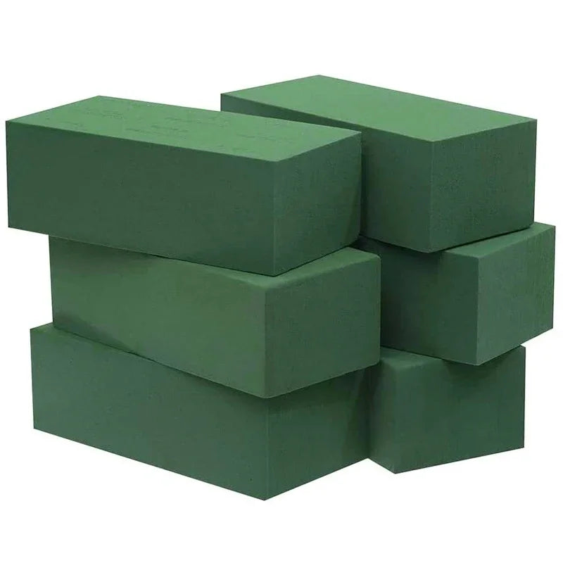 A stack of rectangular, dark green floral foam blocks used for party decoration.