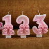 Tres toppers de pastel con brillo rosa en forma de 1, 2 y 3 en palitos de vela blancos