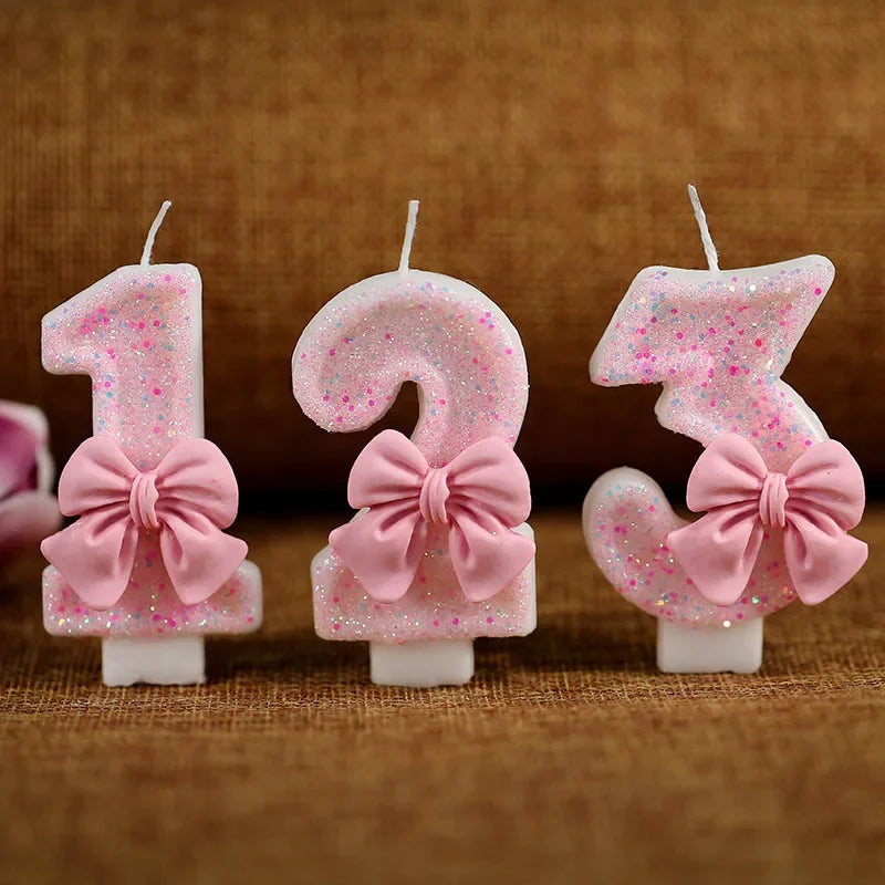 Tres toppers de pastel con brillo rosa en forma de 1, 2 y 3 en palitos de vela blancos