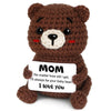 A handcrafted brown crochet teddy bear doll with black eyes and a white nose, featuring the text I love you.