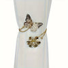 A set of two decorative flower butterfly curtain tiebacks with gold-toned metalwork.