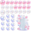 A collection of iridescent pink and clear spherical balloon cake toppers for party desserts.