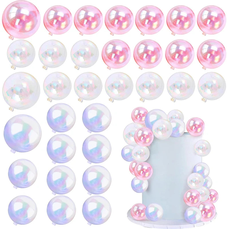 A collection of iridescent pink and clear spherical balloon cake toppers for party desserts.