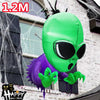 A green inflatable monster decoration with large black eyes and purple skin is shown against a building facade.