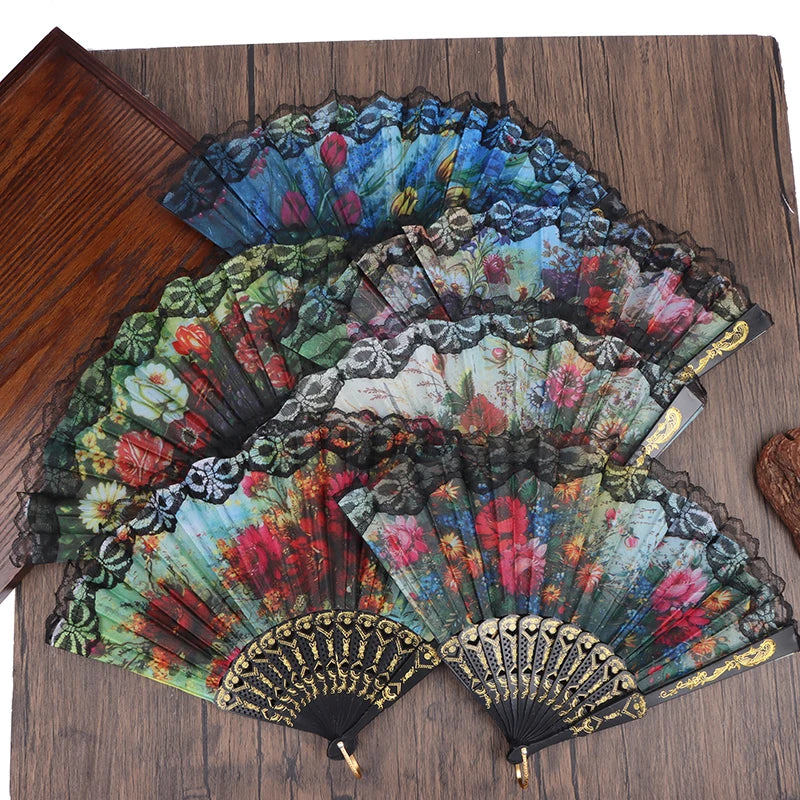 A collection of elegant plum blossom folding fans in various shades of blue, green, and red displayed on a wooden surface.