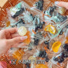 Handmade fruit keychains in various colors like orange and black are packaged in clear plastic bags