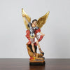 A resin statue of Saint Michael the Archangel with golden wings and armor, standing over a defeated figure.