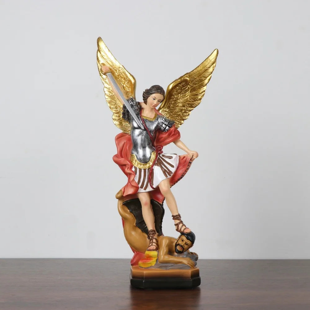 A resin statue of Saint Michael the Archangel with golden wings and armor, standing over a defeated figure.
