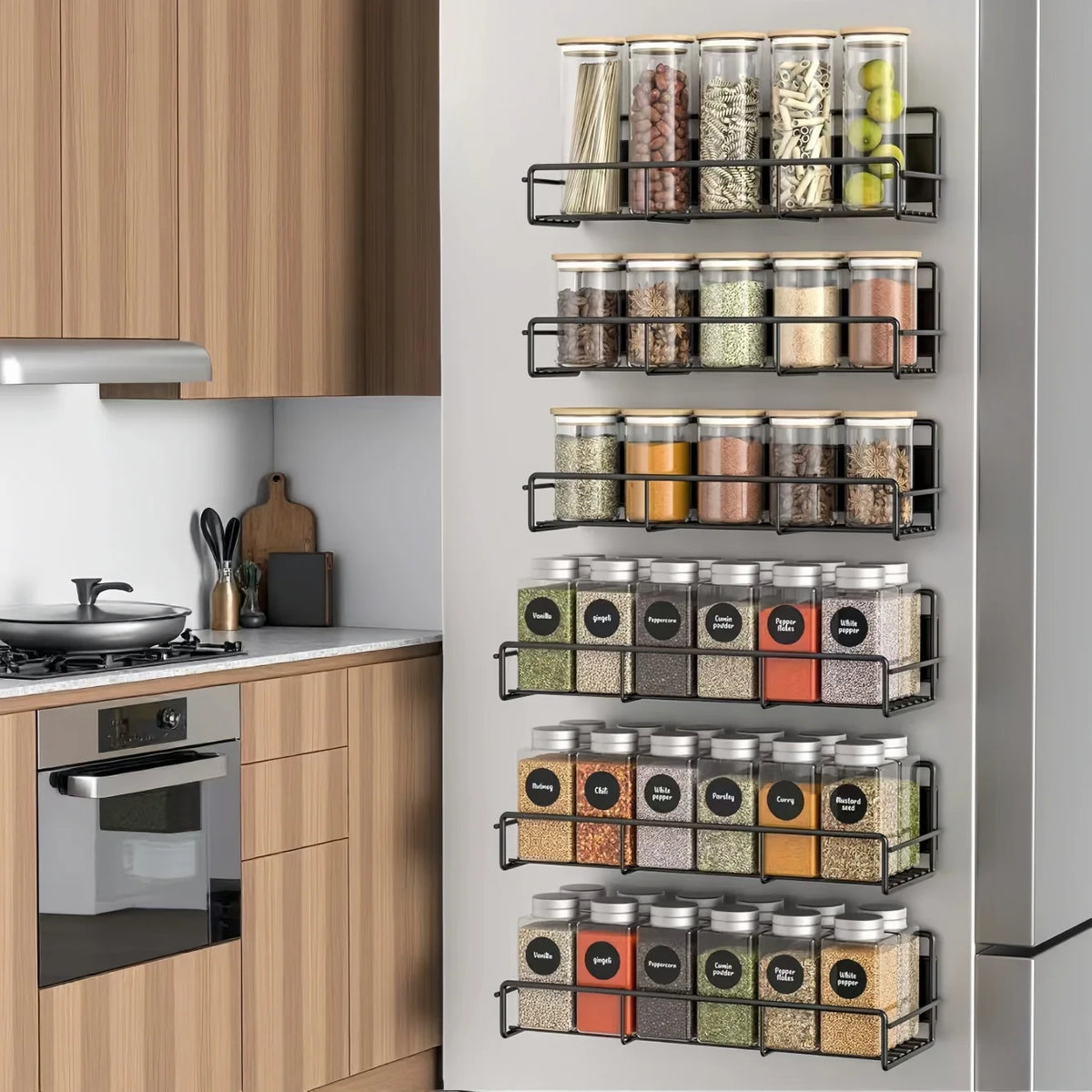 A vertical magnetic spice rack with multiple glass jars holding various spices mounted on a light wood cabinet door.
