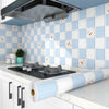 A kitchen countertop with a waterproof oil-proof wall sticker roll and a tiled backsplash.