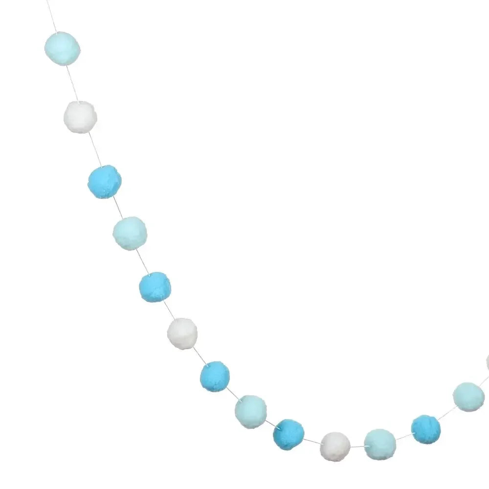 A string of colorful felt balls in shades of blue and white used for home decor.