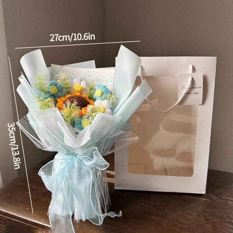 A bouquet of handmade crochet flowers in blue and yellow hues wrapped in sheer light blue fabric.