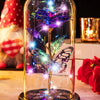 A glass dome features a crystal rose flower illuminated with sparkling light and butterfly wings.