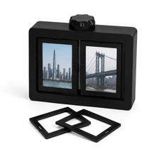 A black 3D rotating photo frame with a glass display and a rotating top, featuring a cityscape.