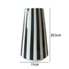 A tall ceramic vase with vertical black and white stripes, shown in a side profile.