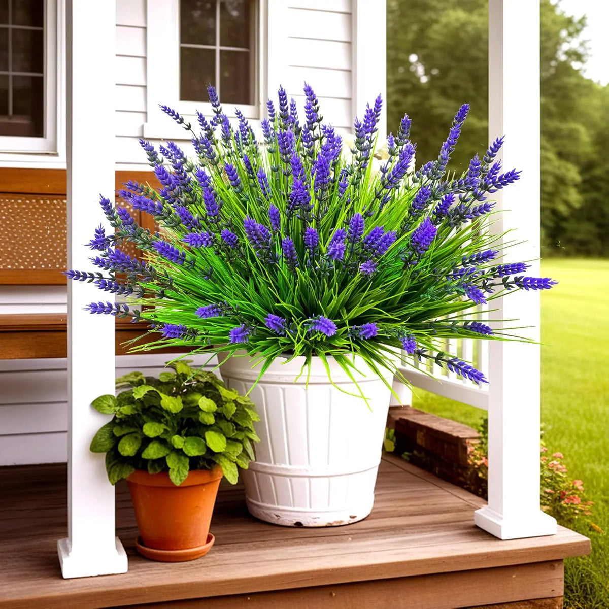 A potted bunch of fresh purple lavender flowers displayed on a wooden porch railing.