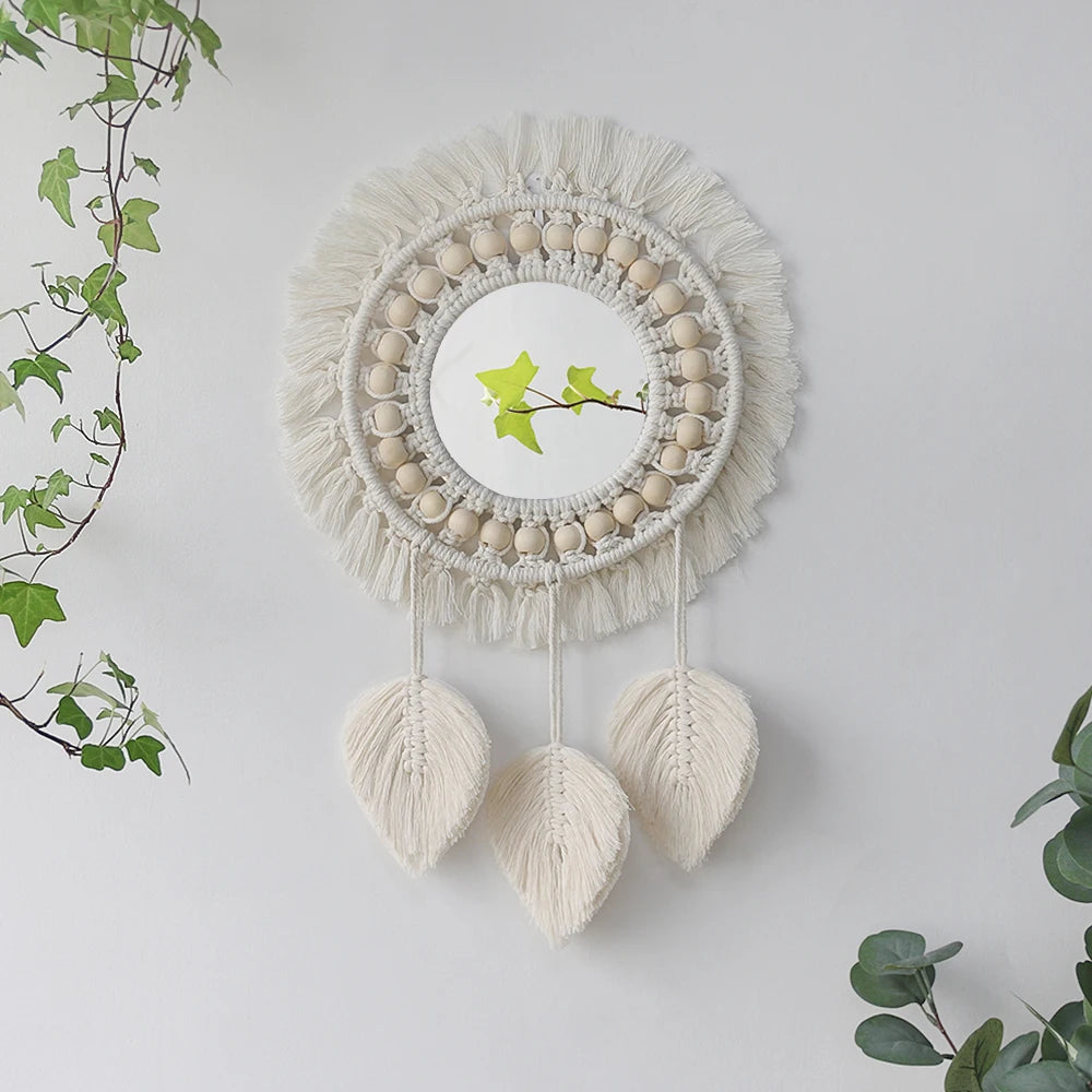 Miroir rond en macramé mural avec frange beige et accents de plumes suspendues.