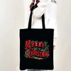 A black tote bag with red text reading Merry Christmas surrounded by green holly and leaves.