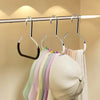 A row of colorful circle ring hats hanging from a silver metal hanger on a clothes rack.