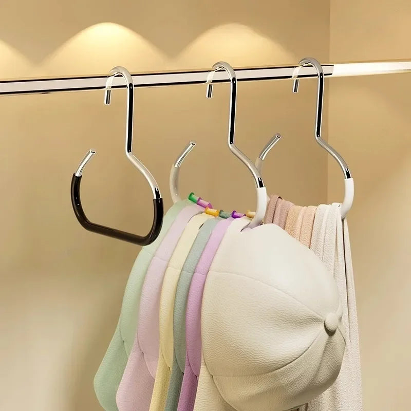 A row of colorful circle ring hats hanging from a silver metal hanger on a clothes rack.