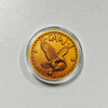 A gold-colored challenge coin featuring a stylized crow with a skull design.