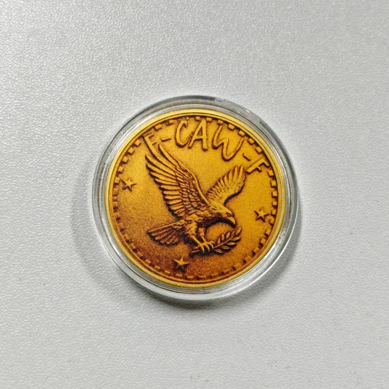 A gold-colored challenge coin featuring a stylized crow with a skull design.