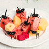 Ant-shaped plastic toothpicks and fruit forks used for serving party snacks like watermelon and fruit.