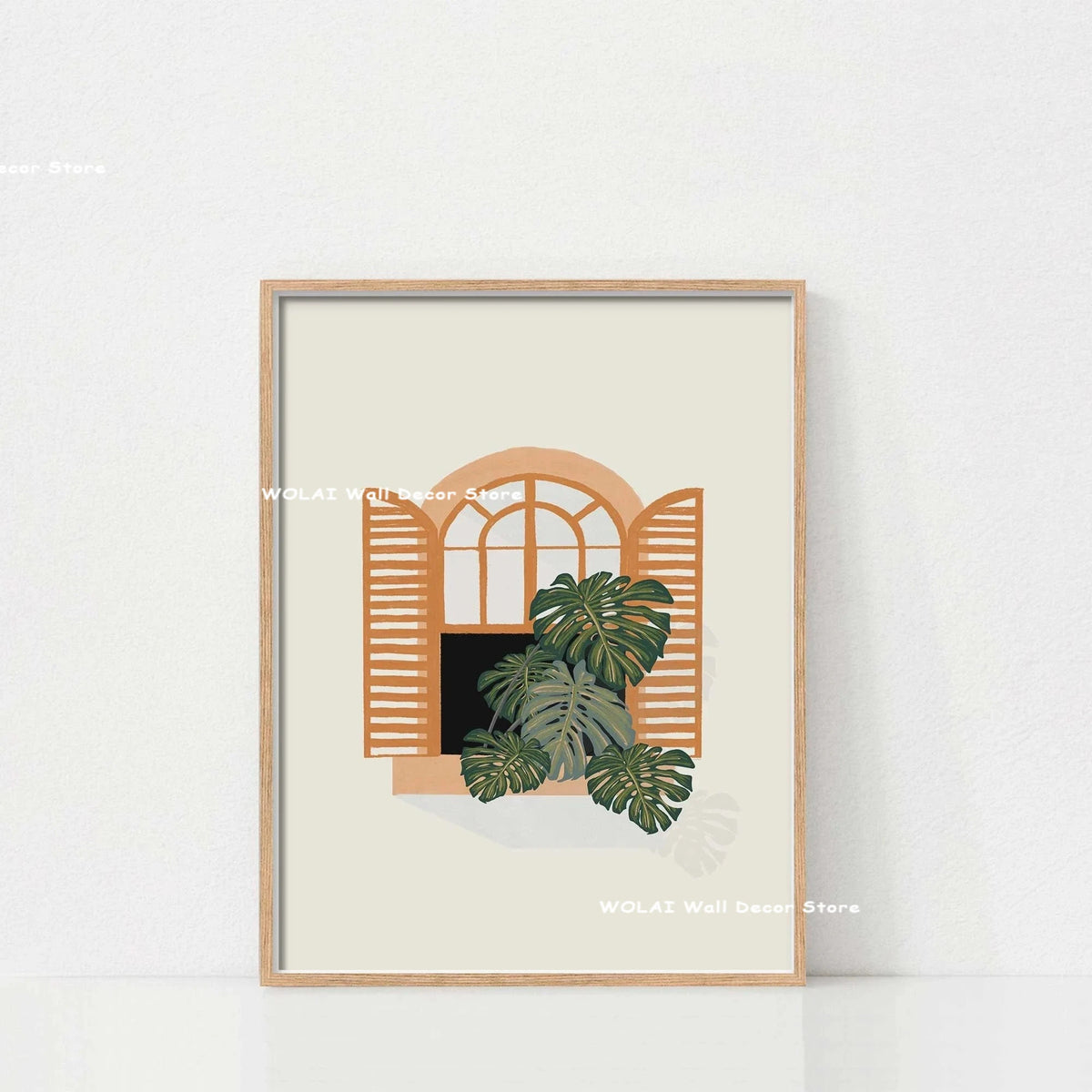 Wall art featuring a framed illustration of an arched window with large green philodendron leaves.