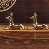 A pair of golden handmade Egyptian Pharaoh dog statues resting on a wooden surface.