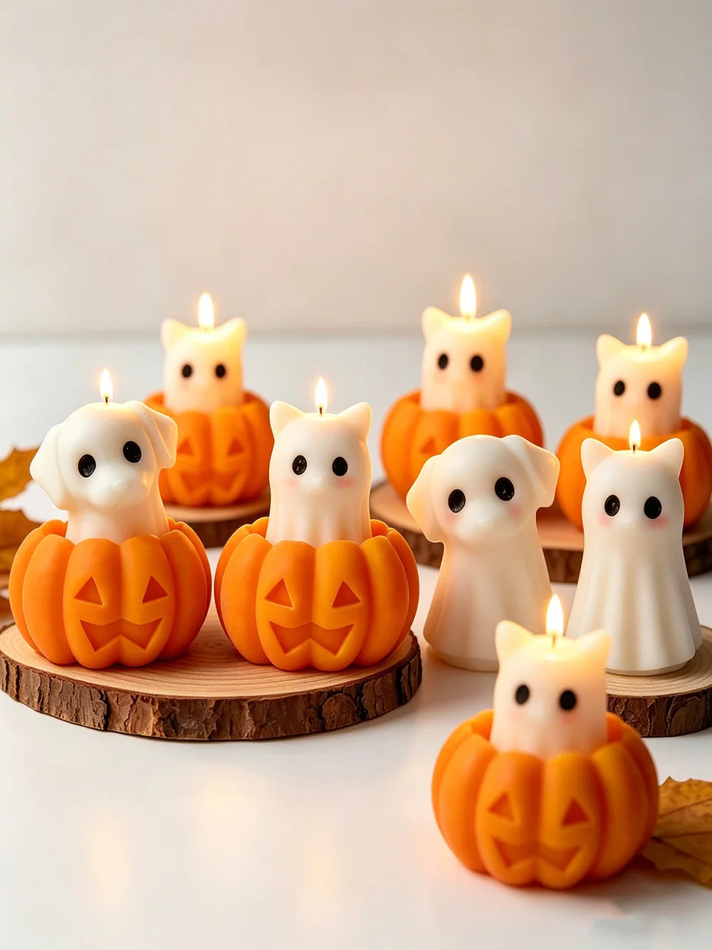 A collection of silicone candle molds featuring cute ghost, cat, dog, and pumpkin designs, lit by candles.
