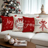 Red Christmas cushion covers featuring white bow and wreath designs on a white sofa.