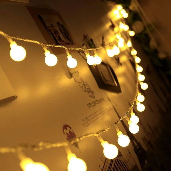 String lights illuminating a product display with warm yellow light.