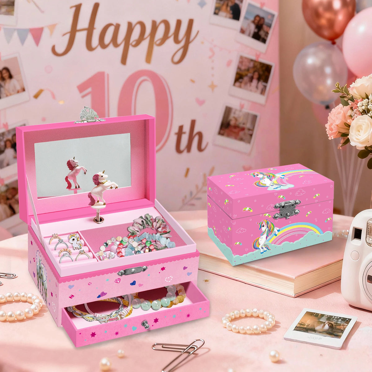 A pink jewelry box shaped like a unicorn with a rotating dancer figurine and various accessories on a pink fabric background.