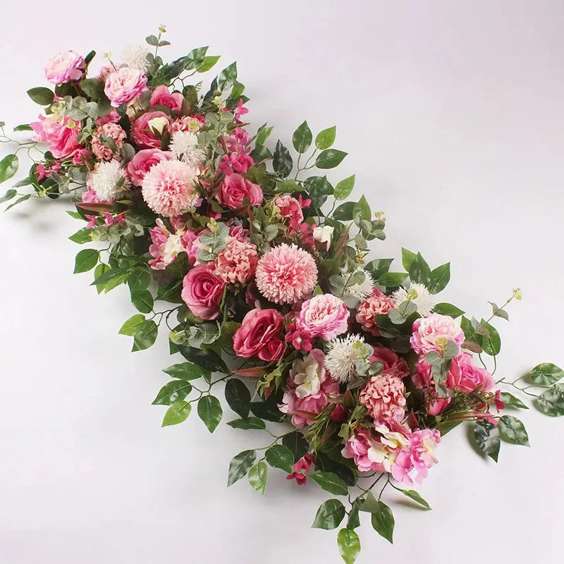 A lush floral arrangement of pink and white artificial roses and greenery for event decor.