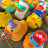 A collection of colorful rubber duck bath toys in various shapes and colors.